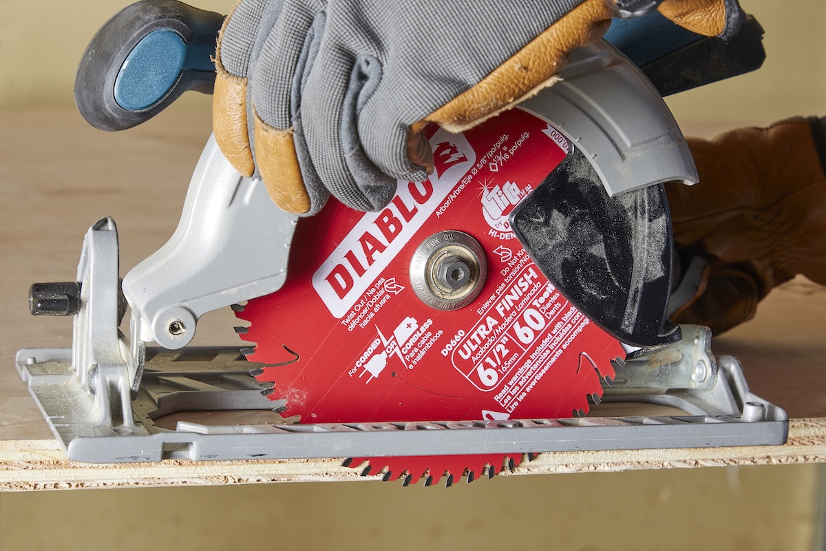 Person using circular saw sets the blade depth to cut plywood.