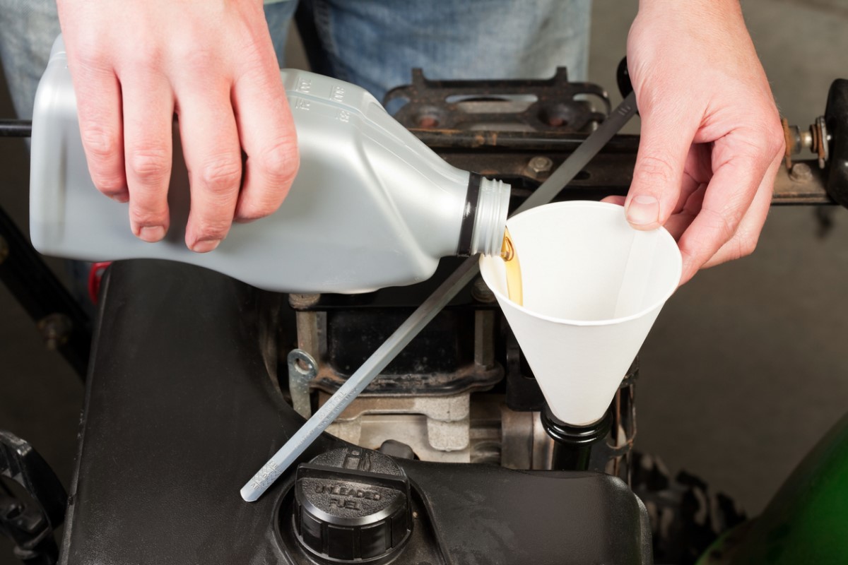 Person changing the oil in a snowblower.