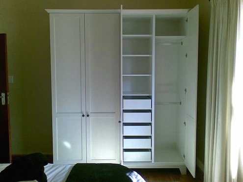 Freestanding white wardrobe with built in drawer storage.