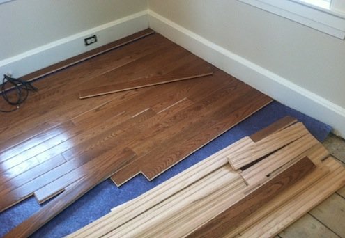 Installing pre-finished hardwood flooring with Bellawood underlayment.