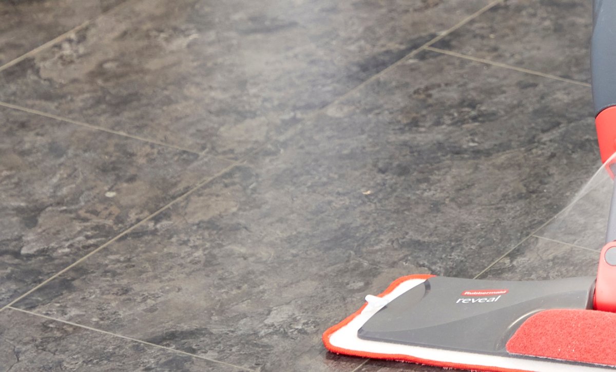 Close up of vinyl flooring with a flat spray mop in the foreground.