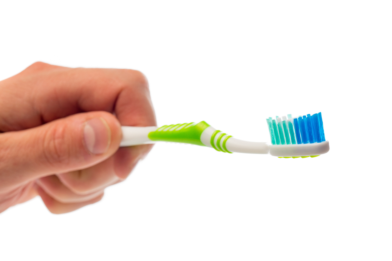 toothbrush in hand on an isolated background