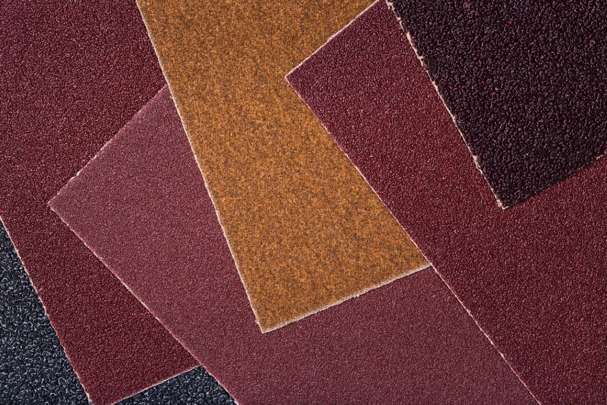 A collection of different colored sandpaper with different grits.