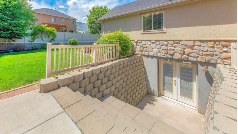 The exterior entrance to a basement leading out to a backyard