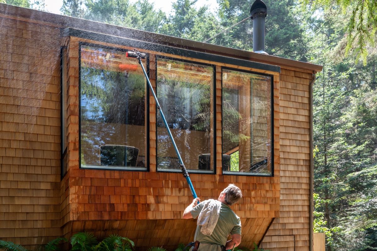 Mean using a long pole to clean the windows outside a house