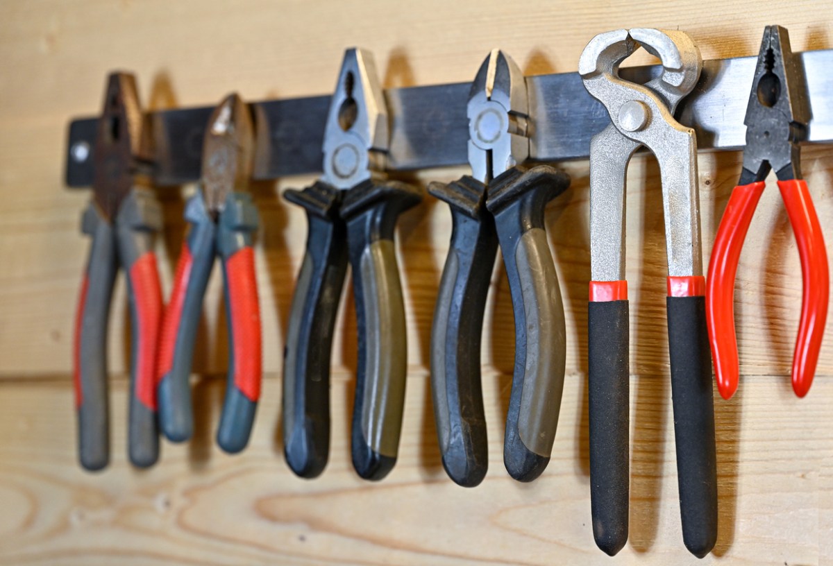 iStock-1370323000 Types of Pliers Various pliers hanging on a magnetic strip on a wall