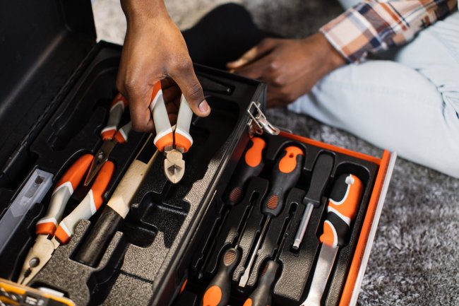 Man man taking pliers out of toolbox