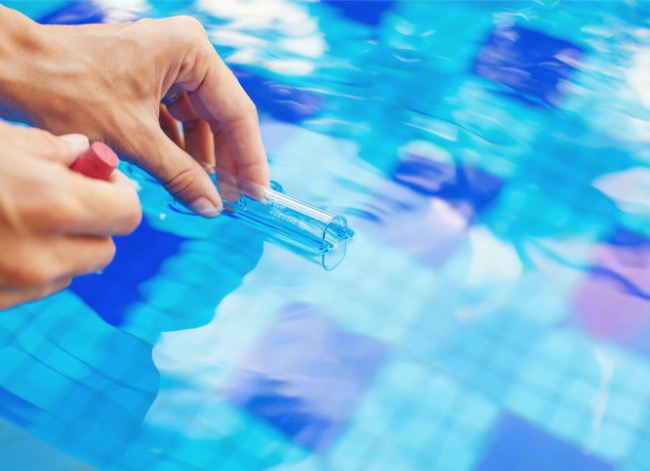 Dipping a test tube into pool water.