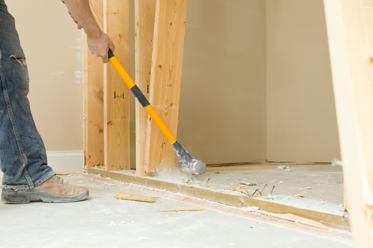 Construction Worker Using a Sledgehammer to Remove Wall Stud