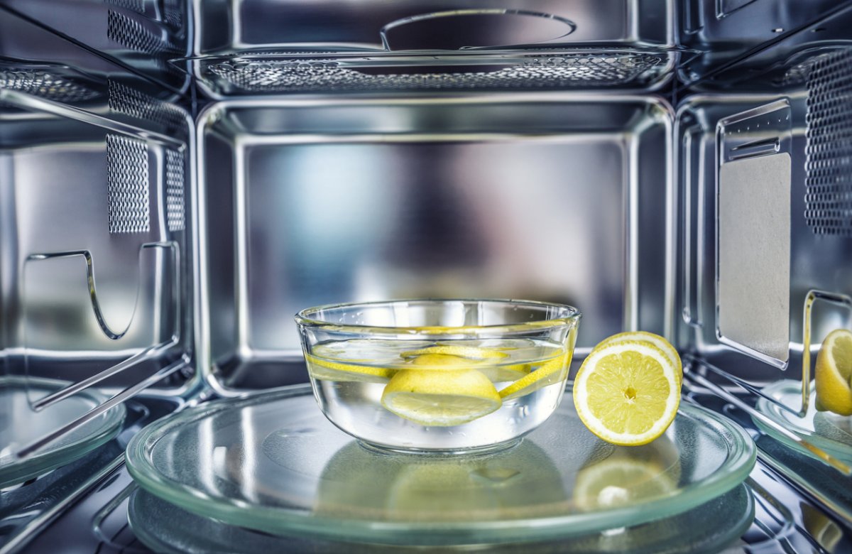 A bowl of water with lemon slices inside a microwave.
