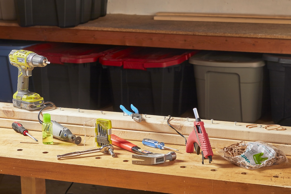 Several tools and materials for removing stripped screws on a home workbench.