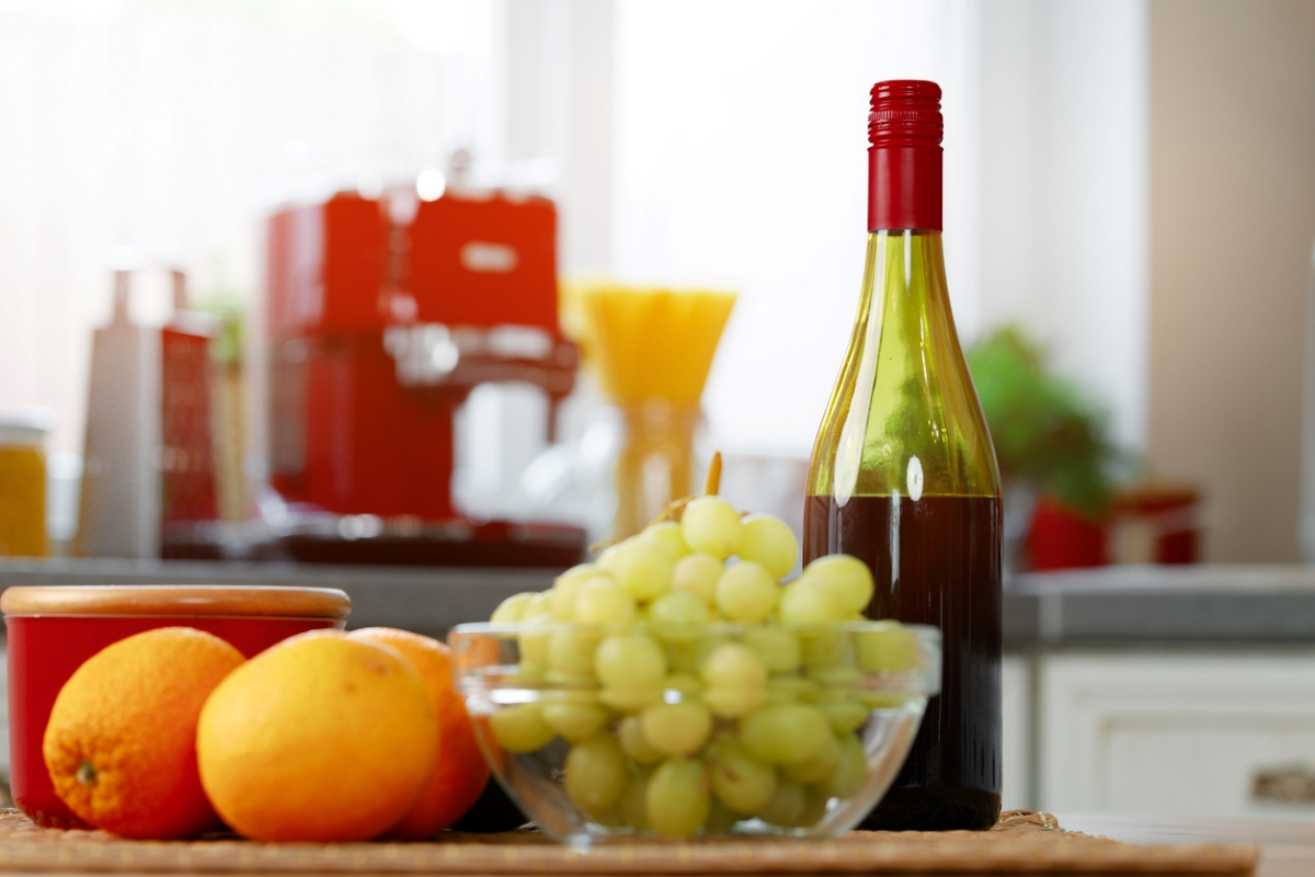 Wine bottle next to fruit in kitchen
