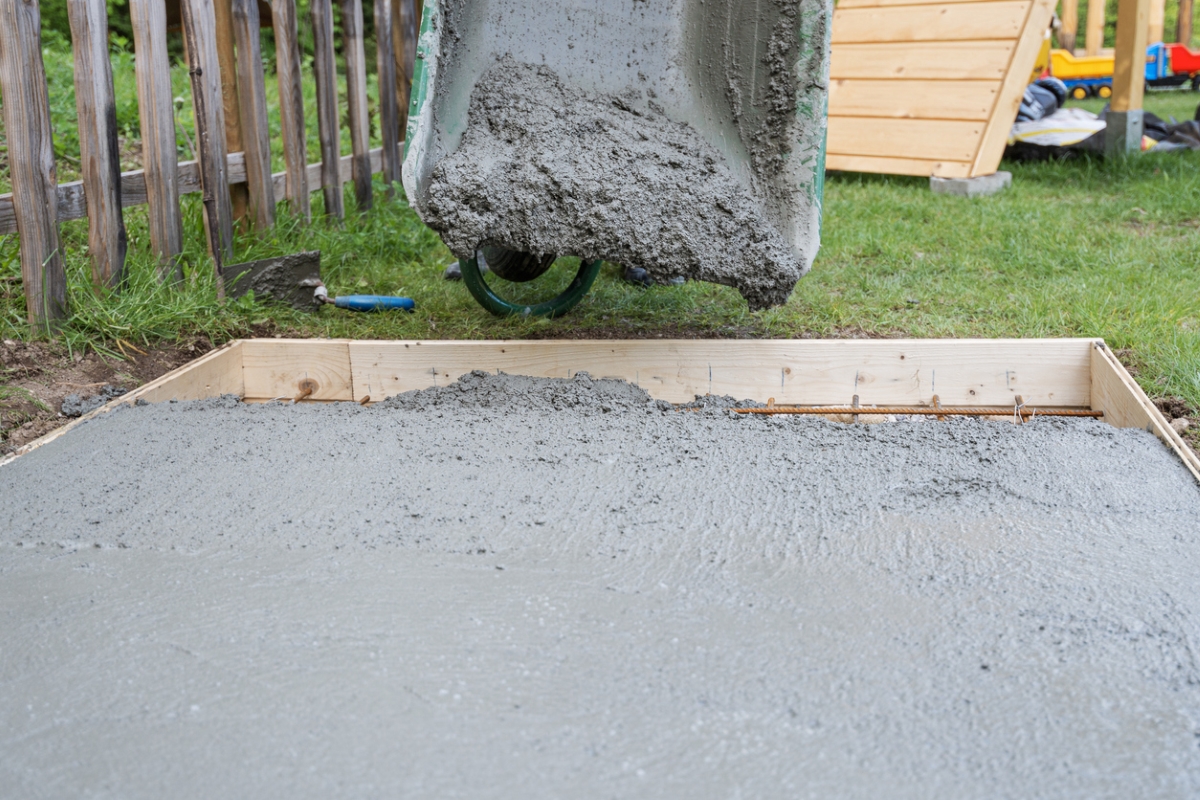 Pouring concrete from wheelbarrow.
