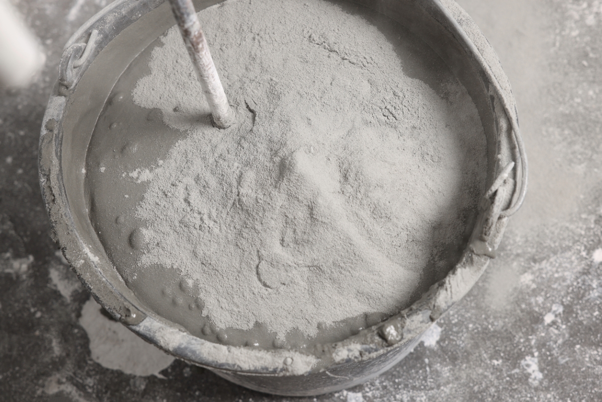 Bucket of concrete with dry cement powder.