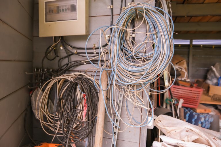 Outdated and disorganized electrical wiring in a residential garage.