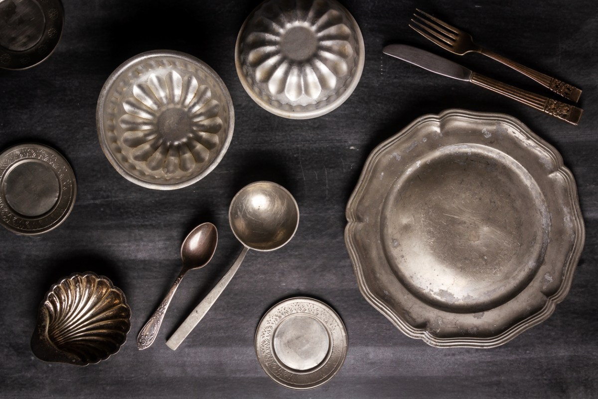 Overhead view of various antique vintage dishes on black table.
