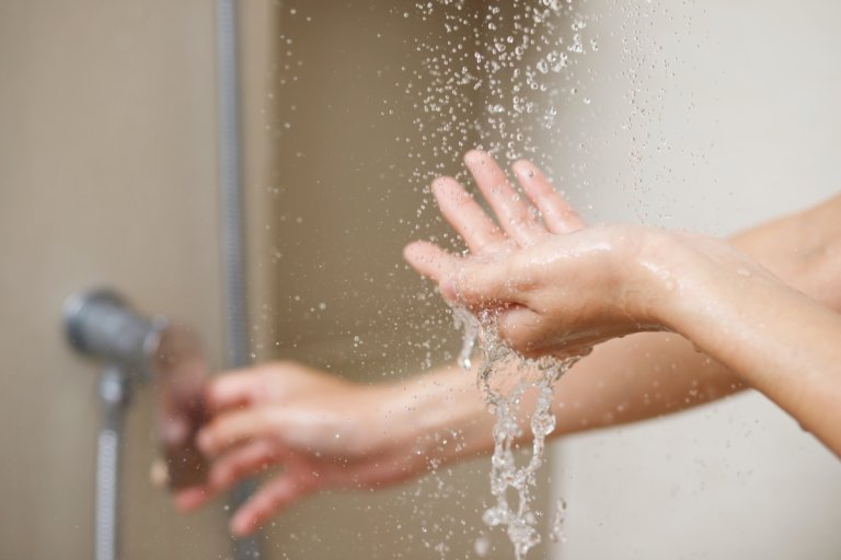 A person testing shower water.