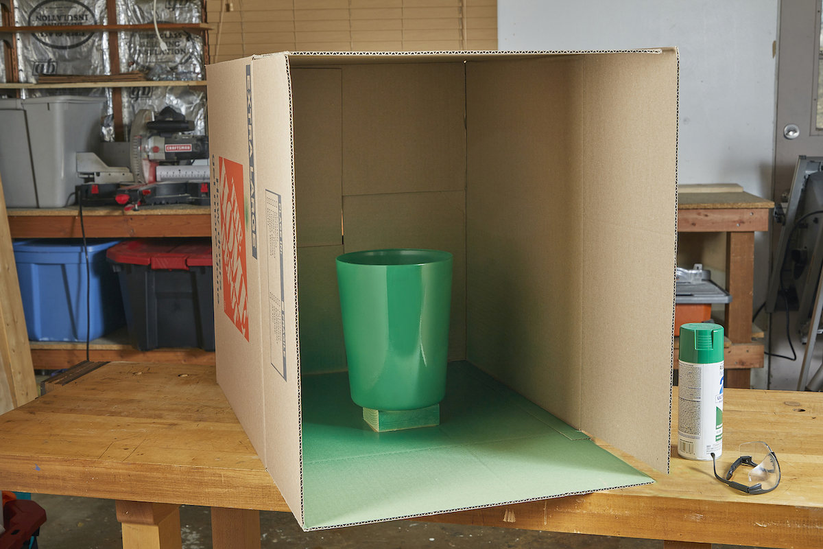 Green painted plastic bin in cardboard box.