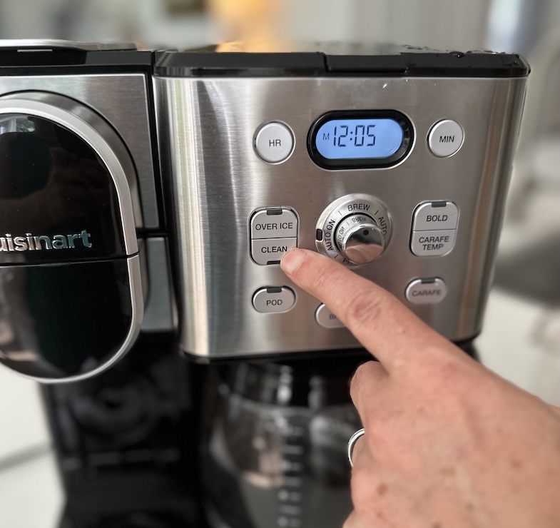 Man pushing the "clean" button on coffee maker
