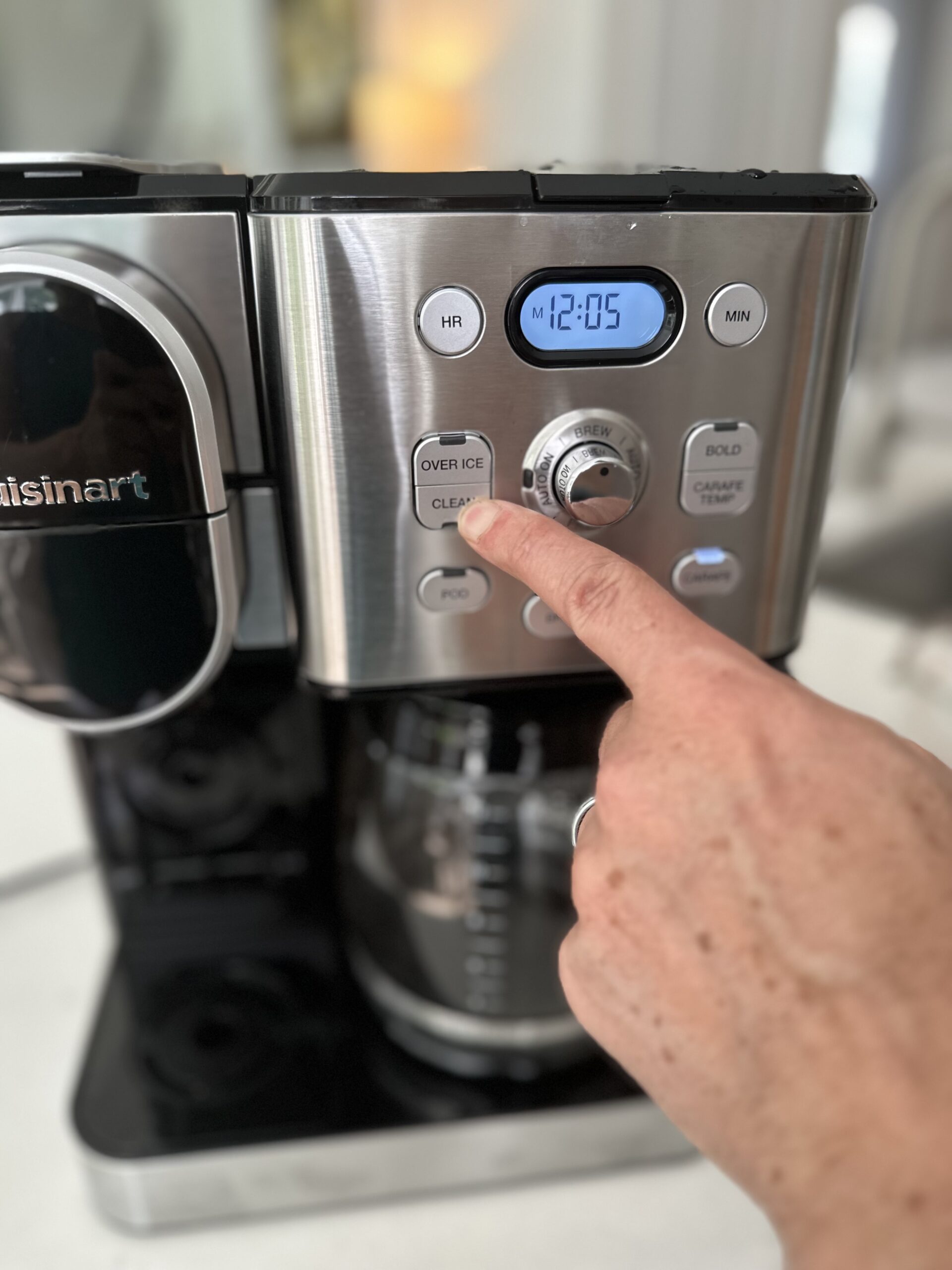 close up of coffee maker with man's hand pressing the clean button