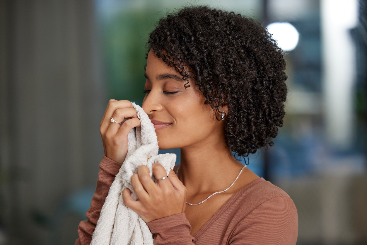 woman smelling a freshly cleaned towel
