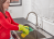 Woman uses olive oil to polish a stainless steel sink.