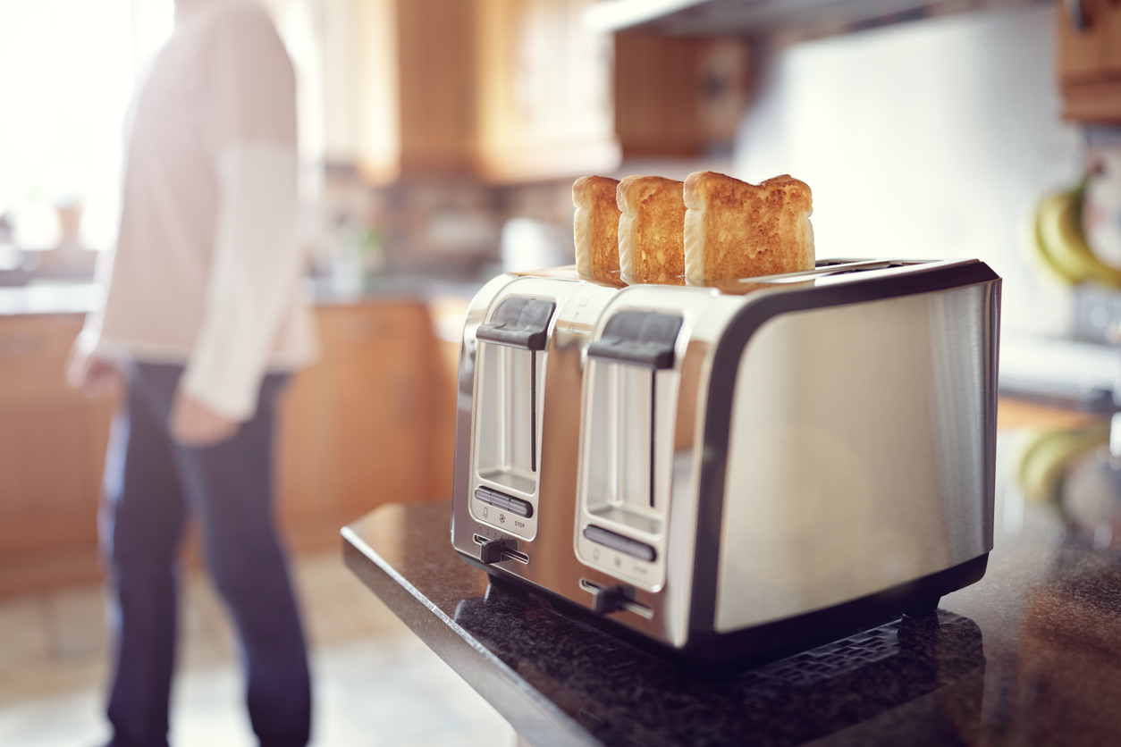 Early morning toasted bread, man in the kitchen preparing toast for breakfast at sunrise