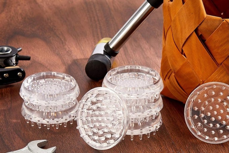 A set of Jetec spiked carpet protectors stacked on a wood floor next to a basket.