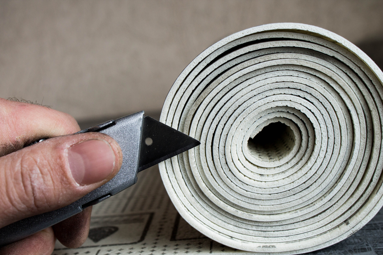 Sliced and rolled linoleum is stacked on a table.