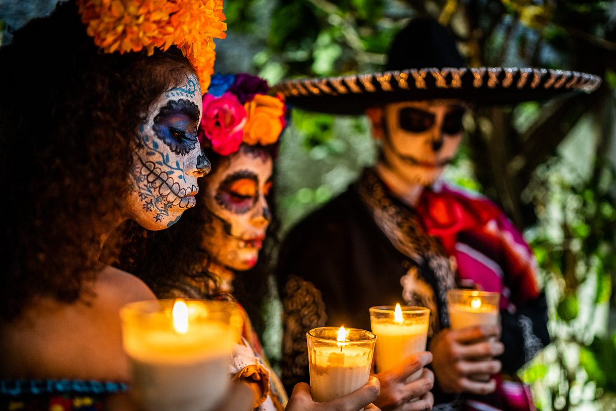 Friends celebrating the day of the dead lighting candle