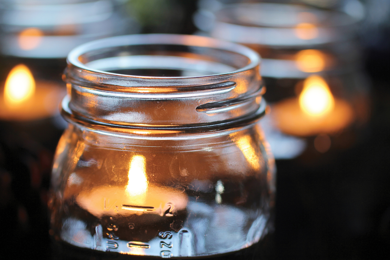Lighted candles floating in canning jars