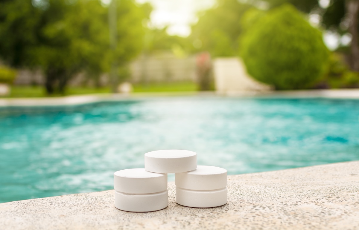 Stack of chlorine tablets on the side of a swimming pool.