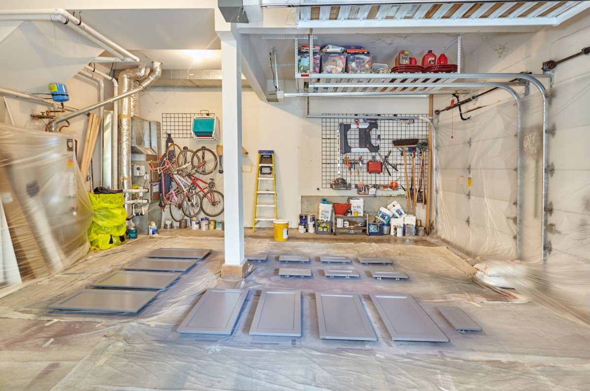 Cabinet doors and drawer fronts drying on the floor after being spray painted in the garage.