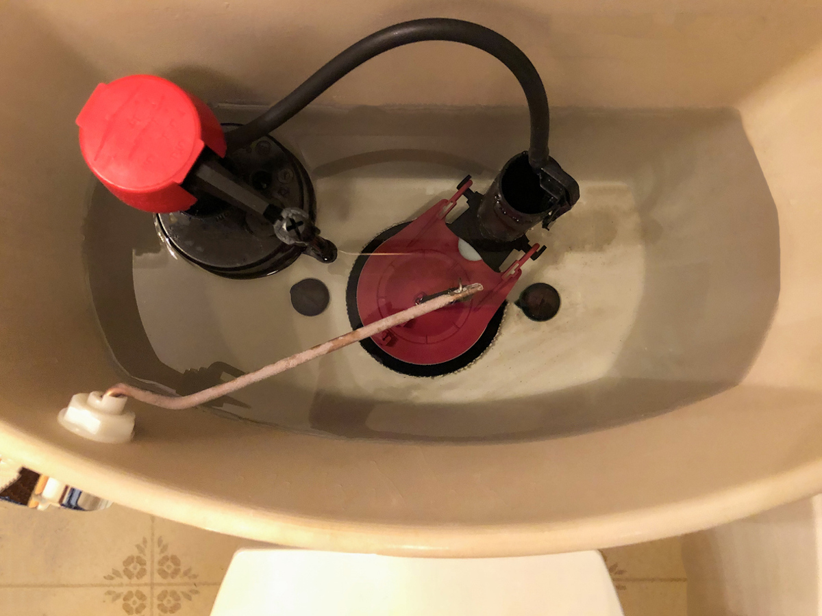 An overhead view of the plumbing inside a toilet tank.