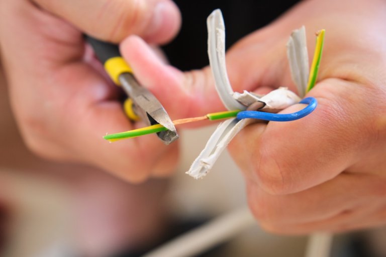 Person using pliers to splice electrical wires.