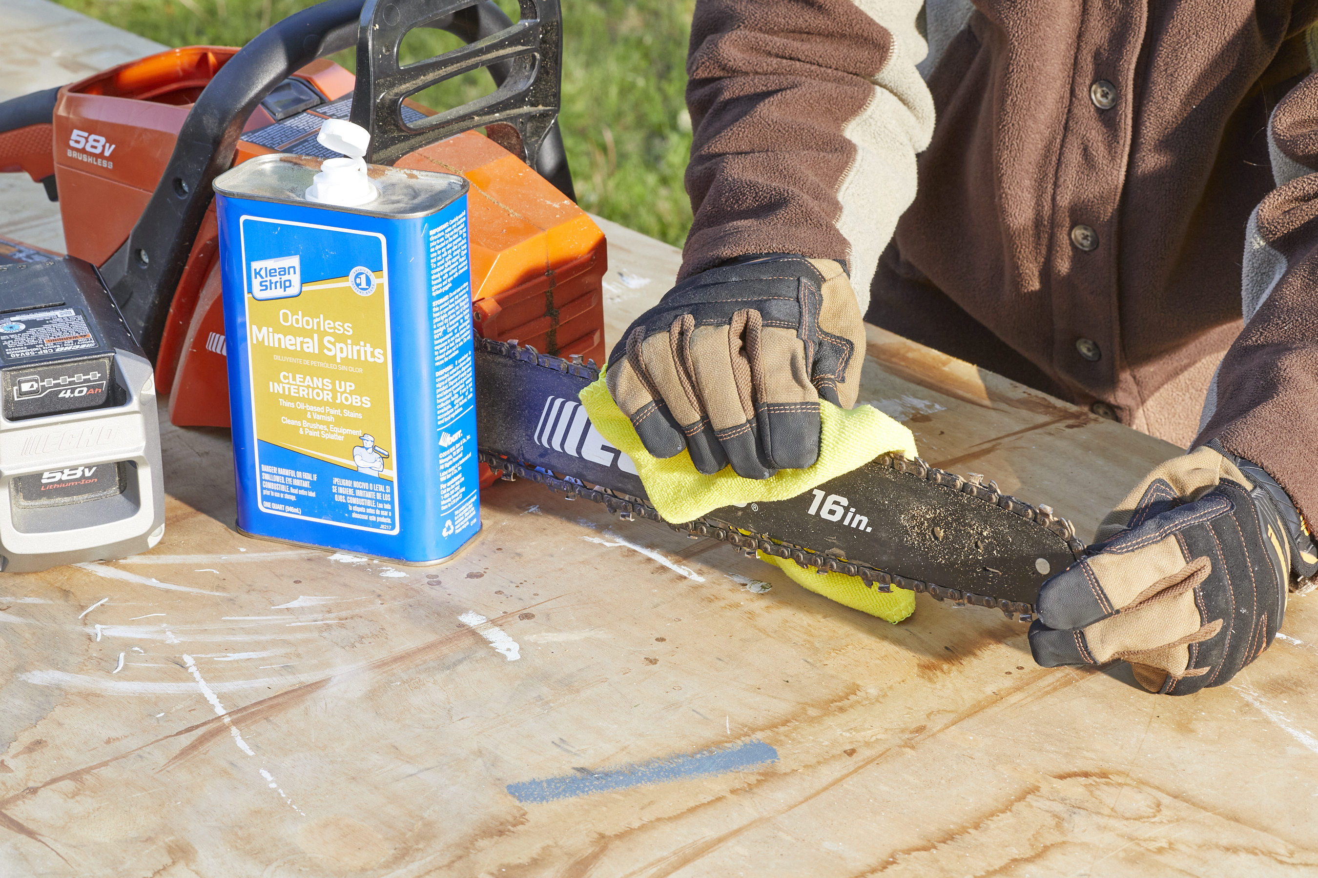 Woman uses a microfiber cloth and mineral spirits to clean a chainsaw. 