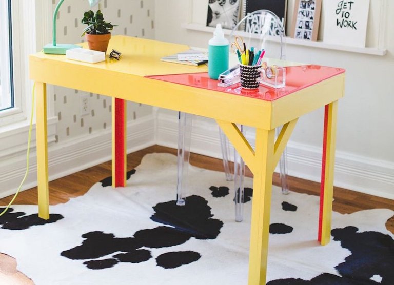 A yellow desk stop a cow-print rug