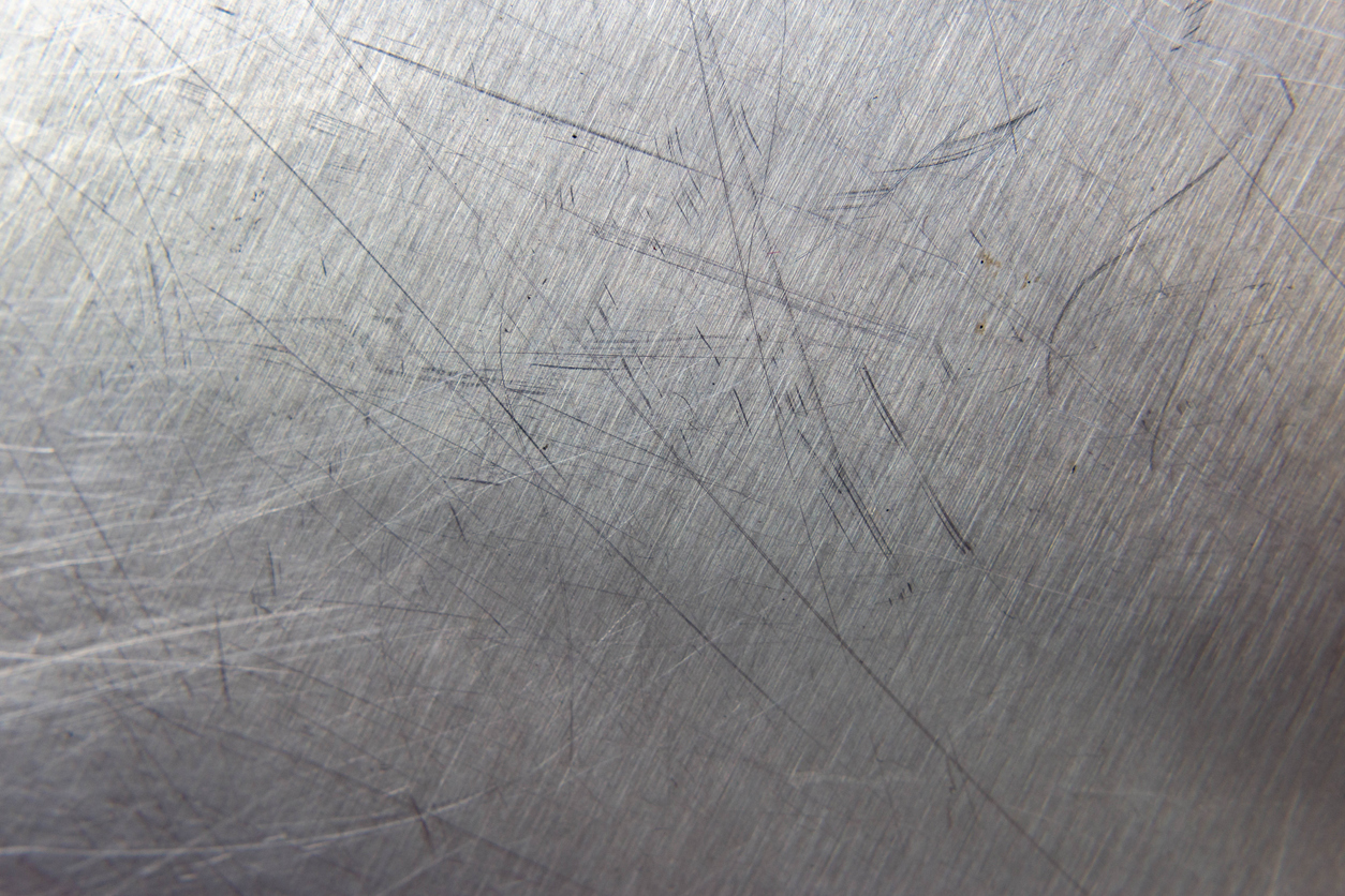 close up of stainless steel counter top with several large scratches