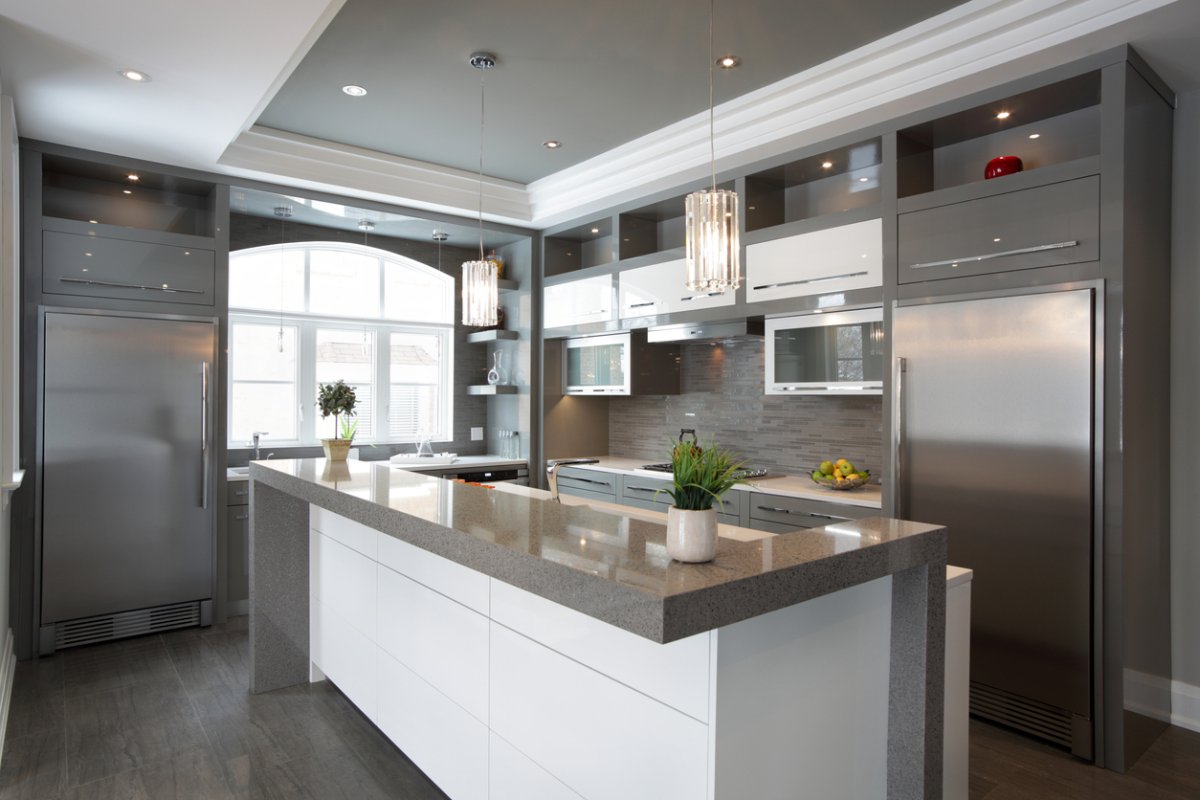 View of modern luxury kitchen with island and stainless steel appliances.