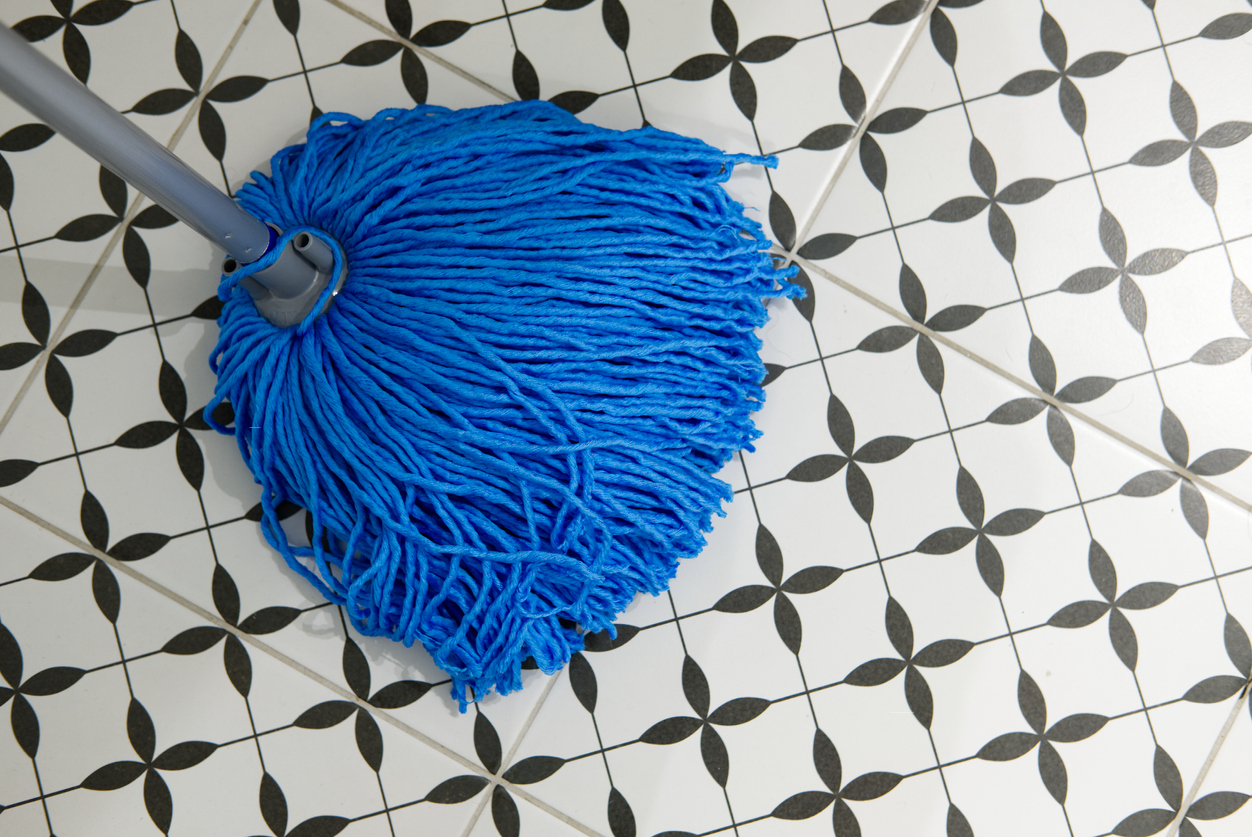 blue mop brush on black and white bathroom floor