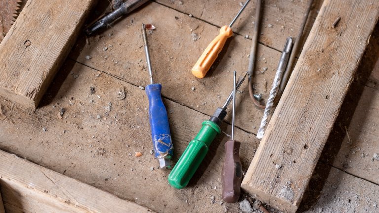 Several screwdrivers on a wooden workbench.