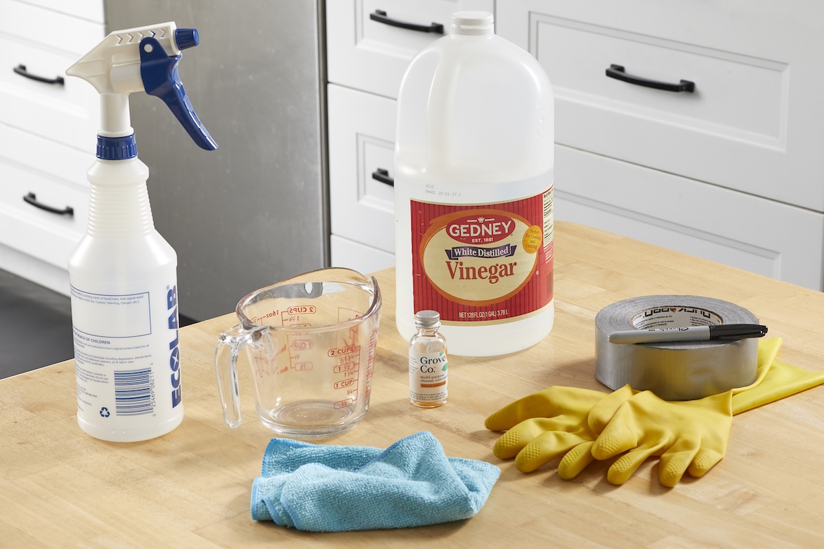 Materials needed to make homemade all-purpose cleaner, including vinegar, essential oil, and other items.