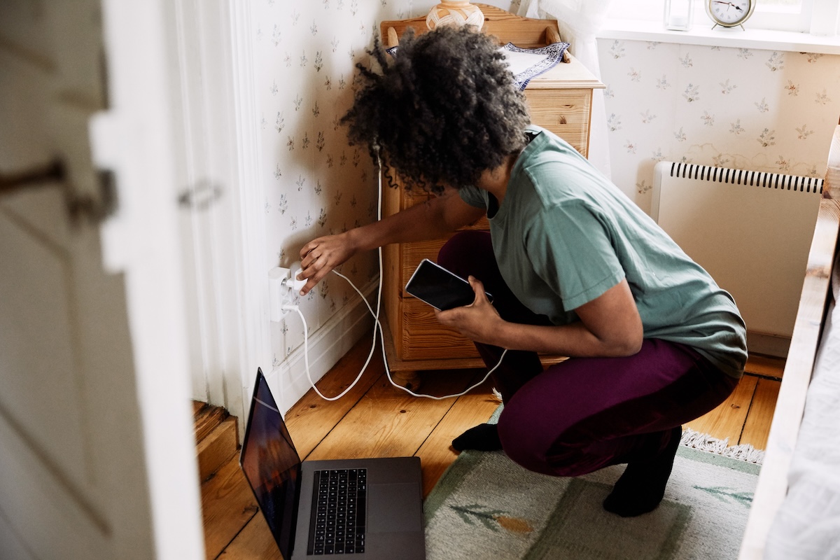 A woman charges her laptop and phone.