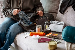 A person pack emergency supplies in preparation of a natural disaster.