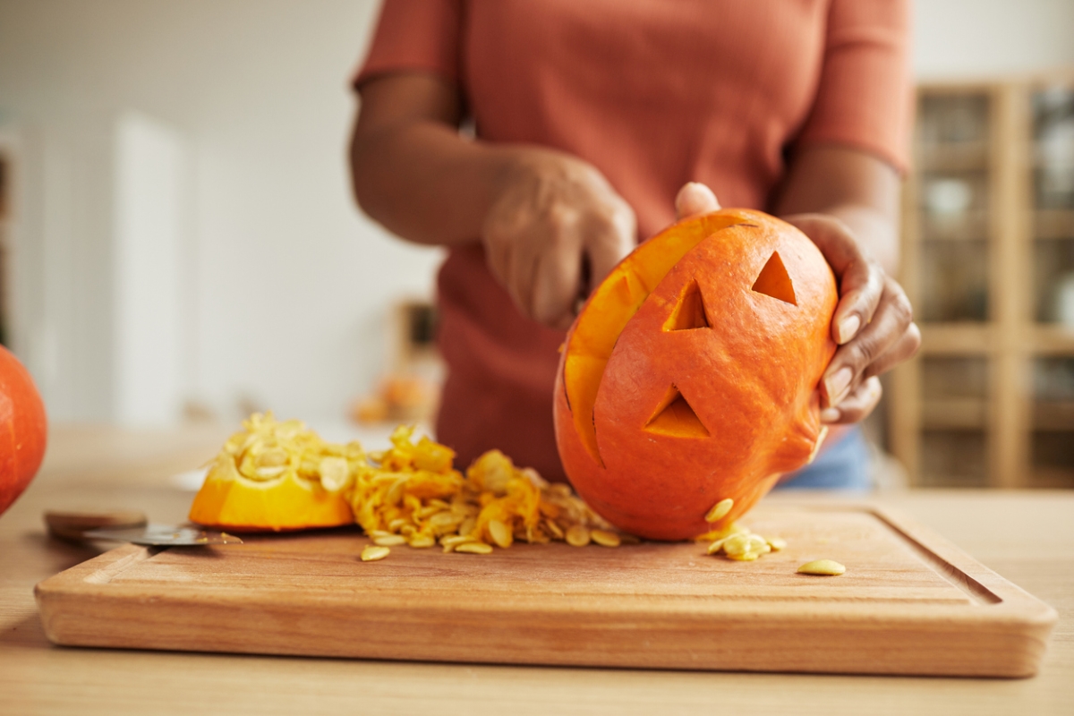 Person carving pumpkin from bottom