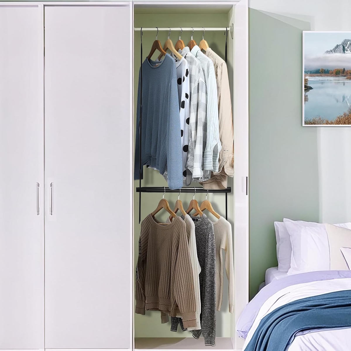 Two Storage Maniac hanging closet rods in a narrow white closet, with shirts and sweaters hanging on both levels.