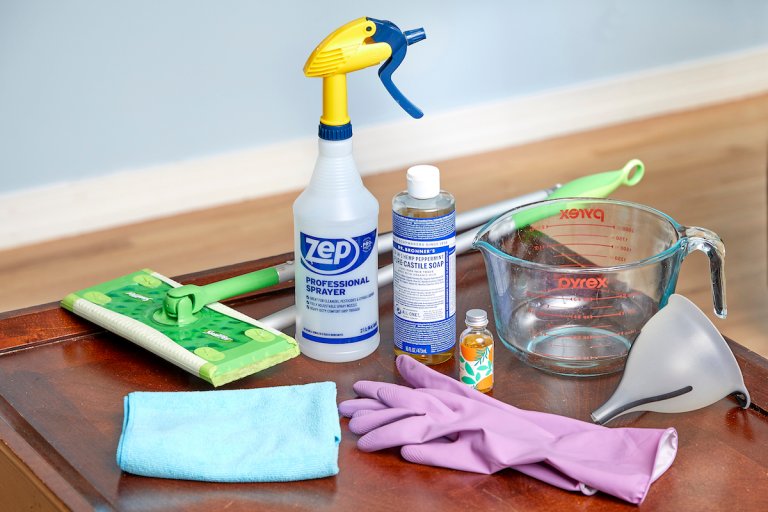 Materials needed to make homemade floor cleaner and apply it to hardwood floors, including spray bottle, mop, and castile soap.