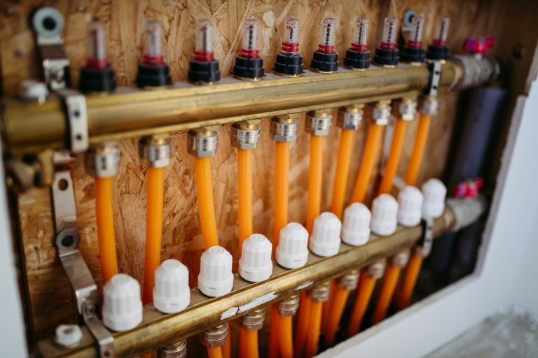 A row of floor heating distribution PEX Pipes.