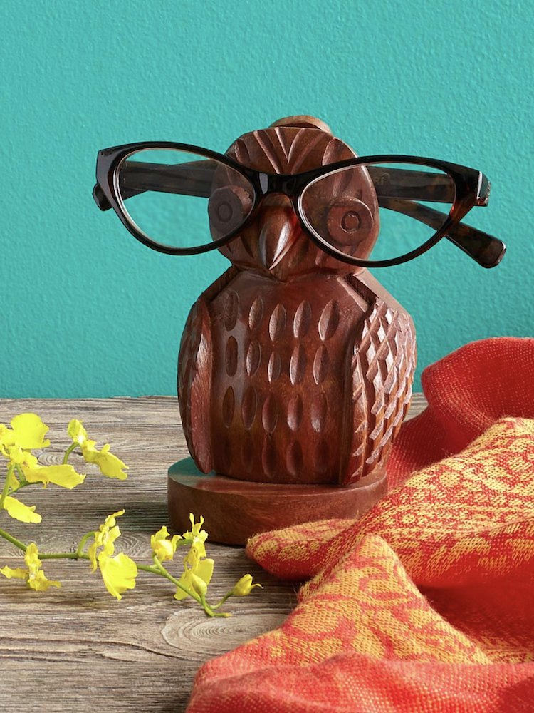 Wooden owl with eyeglasses perched on the break