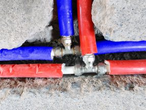 Two sets of red and blue PEX pipes converge.